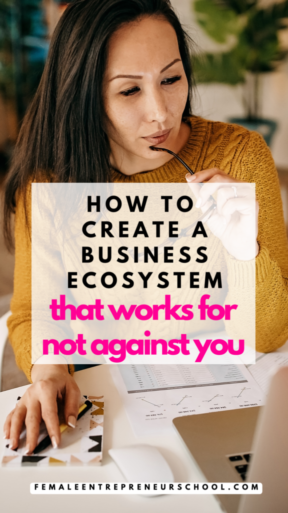 How to create a business ecosystem that works for not against you. Woman at desk in background with long dark hair, mustard coloured jumper hand on desk over a pad, arm of glasses held to lips, part of her laptop on show in the bottom right corner